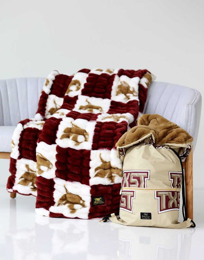 Texas Bobcats Hugs Minky Couture blanket on a chair with matching Texas State drawstring bag beside it.