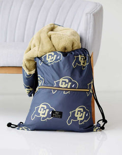 Colorado Buffaloes Minky Couture drawstring bag holding a soft gold plush blanket.