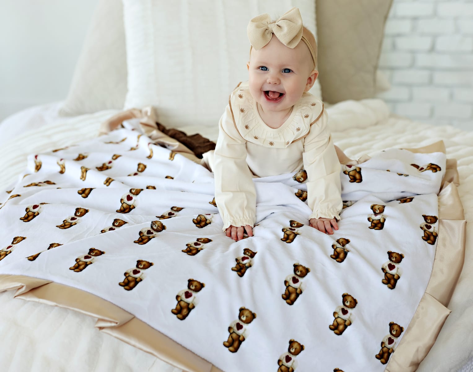Sweetheart Bear Blanket featuring an adorable baby smiling while sitting on the blanket with bear prints.