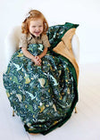 Minky Couture Little Dino Green Blanket featuring colorful dinosaurs with a child happily wrapped in it.