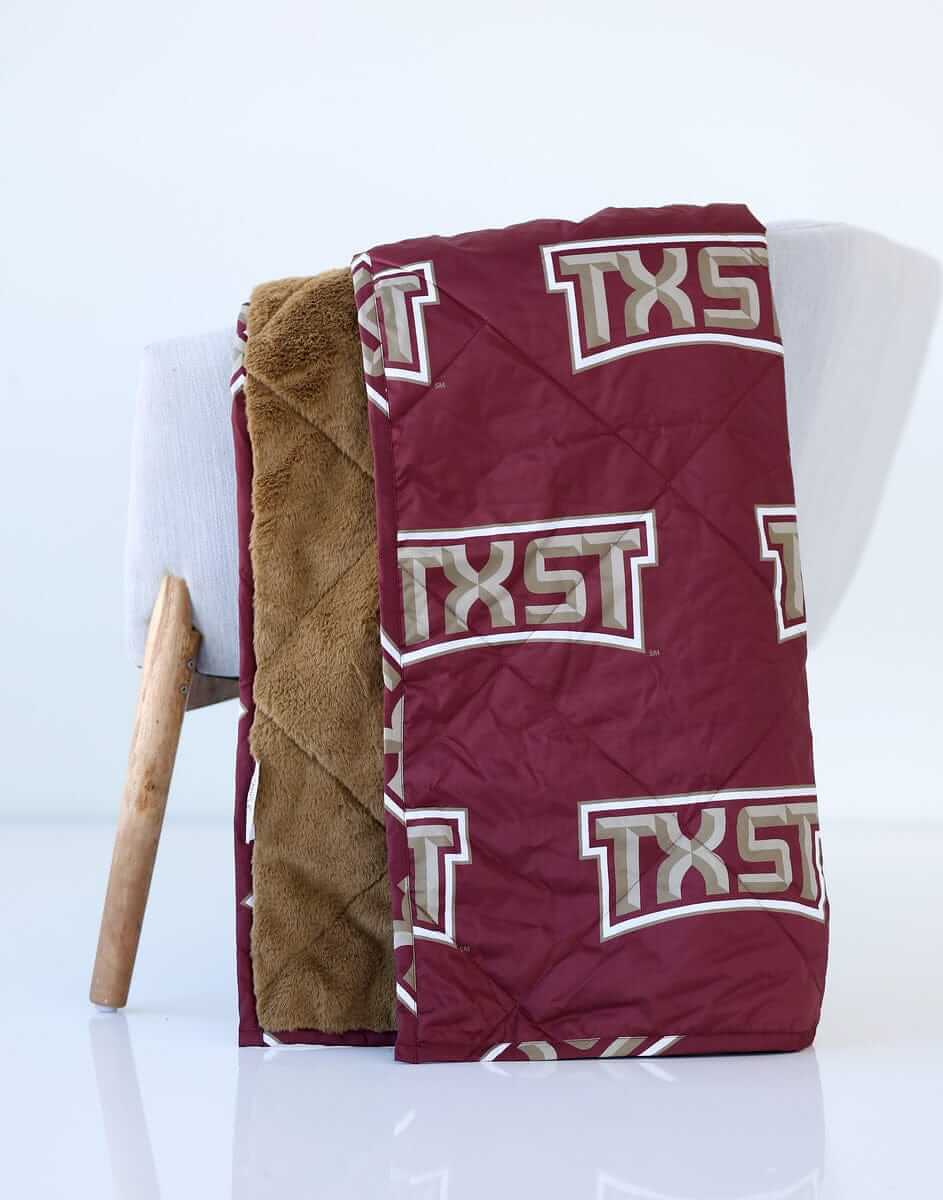 Texas State Bobcats Hooded Stadium Blanket folded with maroon TXST logo and plush lining.