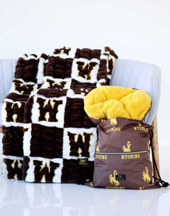 Wyoming Cowboys Hooded Stadium Blanket featuring brown and yellow plush design on a cozy couch.