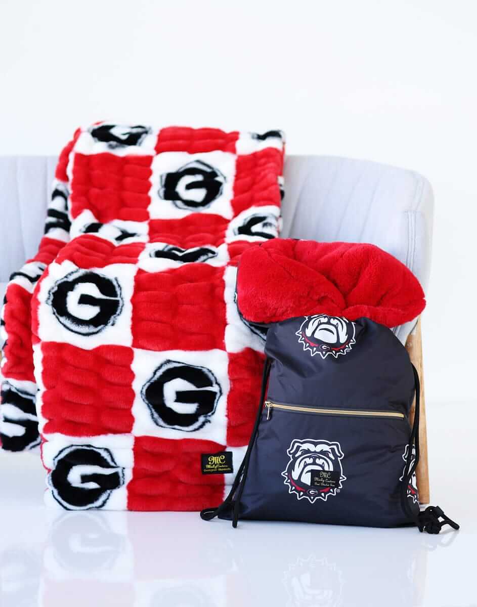 Georgia Bulldogs Hooded Stadium Blanket displayed on a chair with coordinating backpack.
