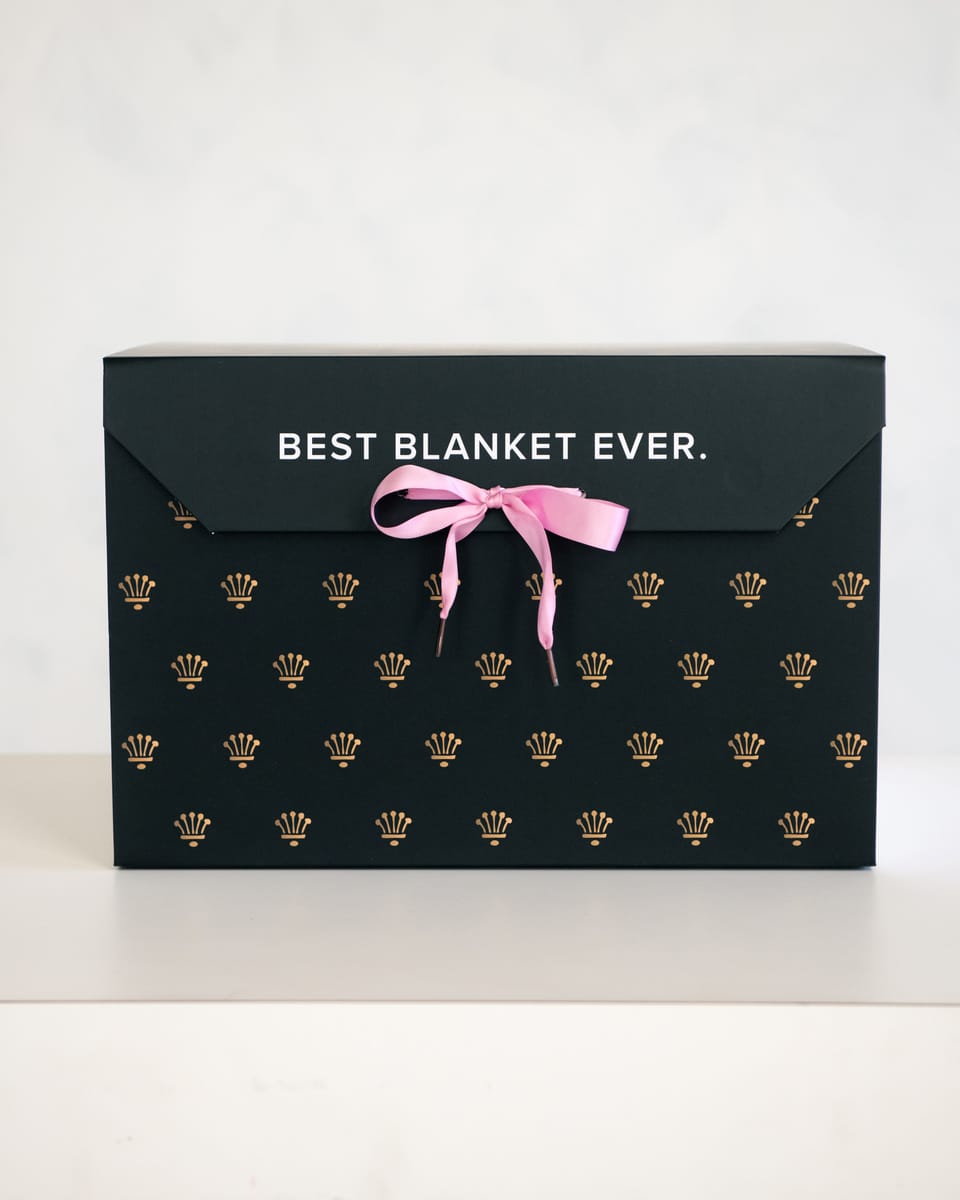 Elegant gift box with the text 'BEST BLANKET EVER' featuring a pink ribbon, perfect for gifting cozy blankets.
