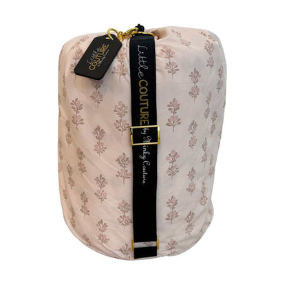 Hampton Blooms baby sleeping bag rolled with black Little Couture strap and gold hardware.