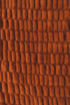 A close-up of warm rust-orange colored blanket.