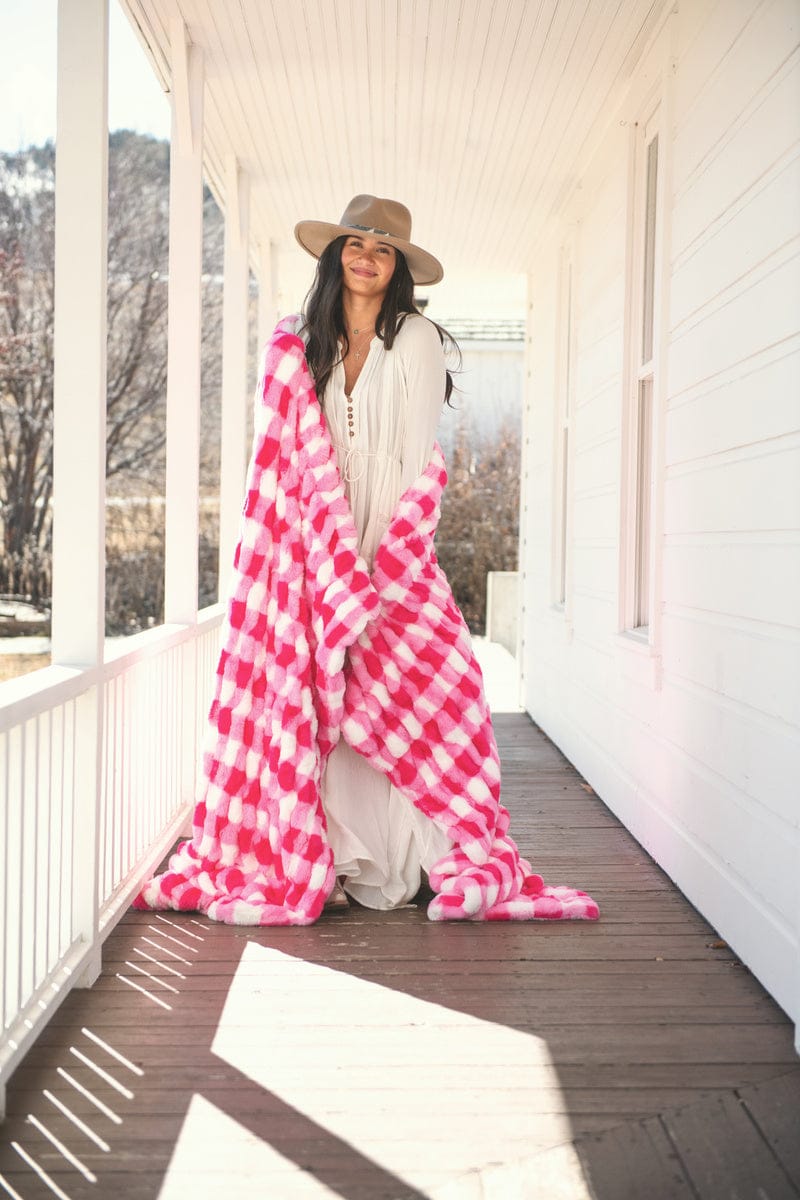 Young lady wrapped up in a hot pink gingham check stretchy blanket.