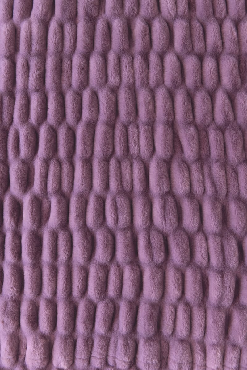 A close-up of a lavender-purple colored blanket.