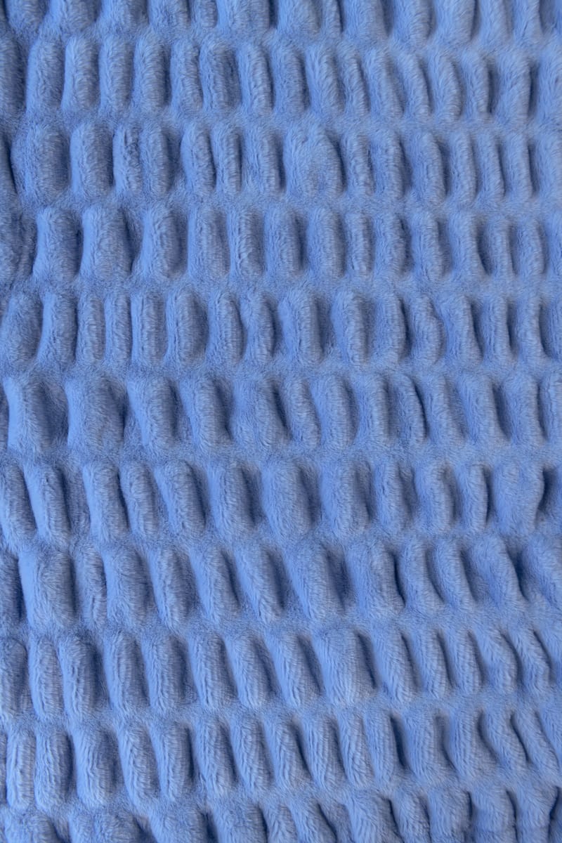 Close-up of textured blue fabric with a stretchy pattern