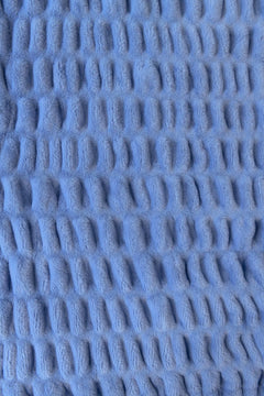Close-up of textured blue fabric with a stretchy pattern