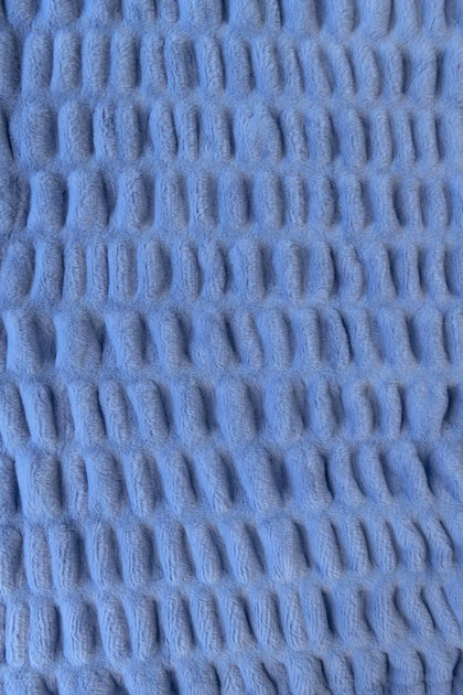 Close-up of textured blue fabric with a stretchy pattern