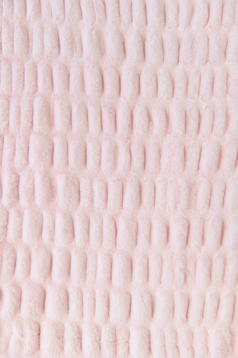 Close-up of a textured pink fabric blanket

