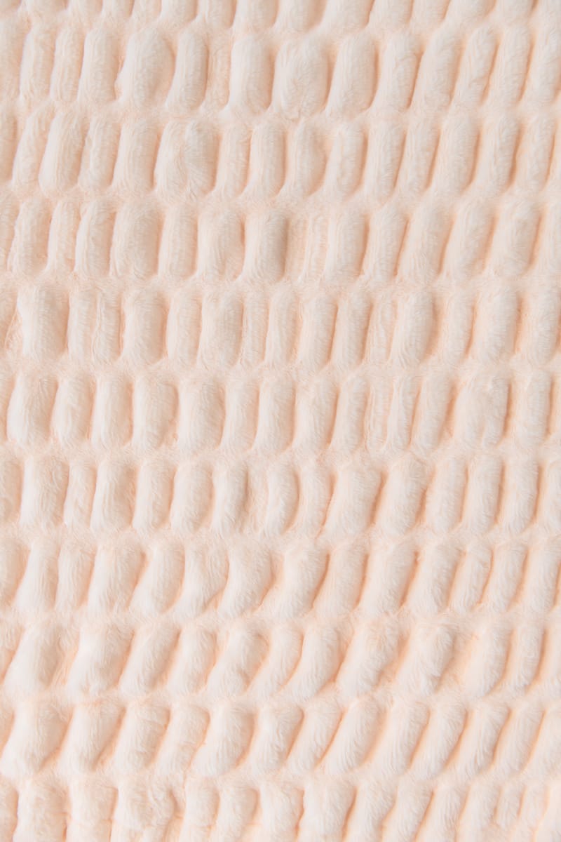 Close-up of textured pastel orange blanket