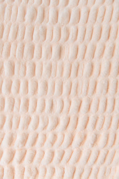 Close-up of textured pastel orange blanket