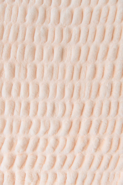 Close-up of textured pastel orange blanket