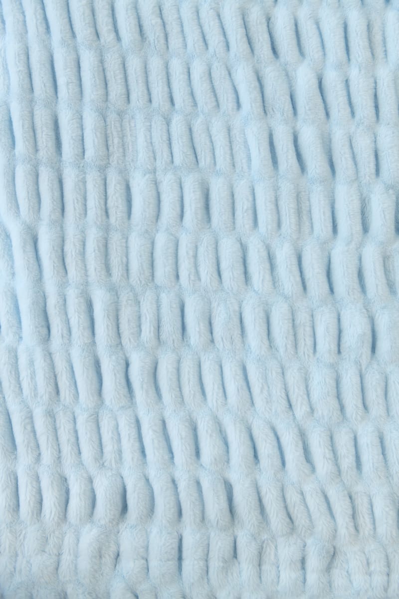 Close-up of textured light blue blanket.
