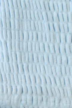 Close-up of textured light blue blanket.