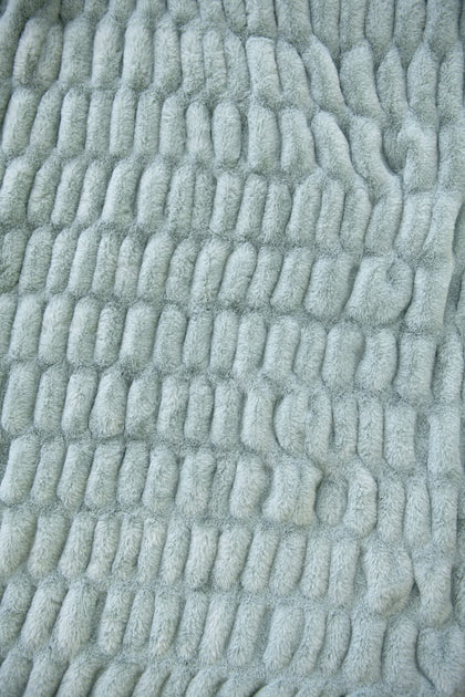 Close-up of textured light blue fabric with a wavy pattern from the Hugs Willow Blue Blanket.