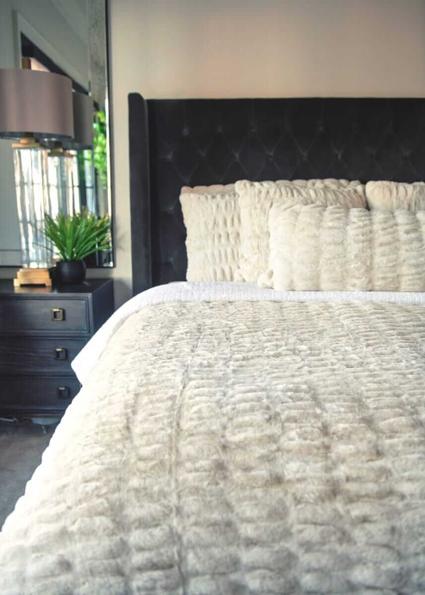 Neutral Minky Couture bedding styled on a bed with textured pillows.