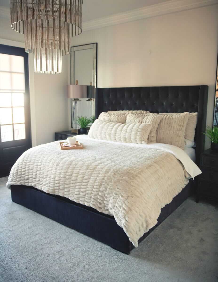 Neatly made bed with Hugs Ancient Scroll Sham Minky Couture bedding and decorative pillows in a bedroom setting.
