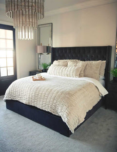 Neatly made bed with Hugs Ancient Scroll Sham Minky Couture bedding and decorative pillows in a bedroom setting.