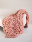 Minky Couture Hugs Blossom Pink textured blanket draped over a white sofa.