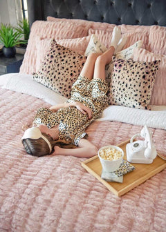Girl relaxing on a bed with Hugs Blush Duvet Minky Couture bedding and pillows.