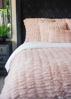 Hugs Blush Duvet Minky Couture bedding with textured pillows on a bed.