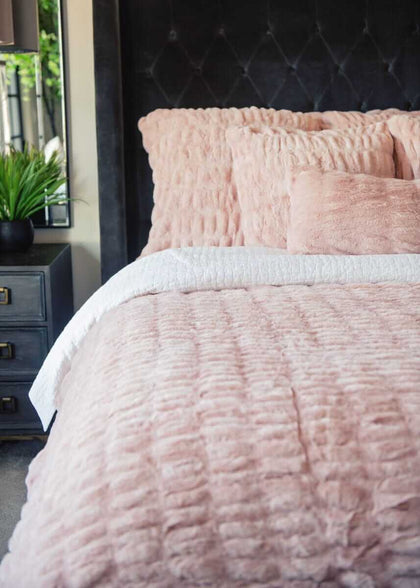 Hugs Blush Duvet Minky Couture bedding with textured pillows on a bed.