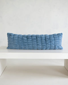 Hugs Denim Sham on a white table, showcasing its soft texture and denim blue color for stylish comfort.
