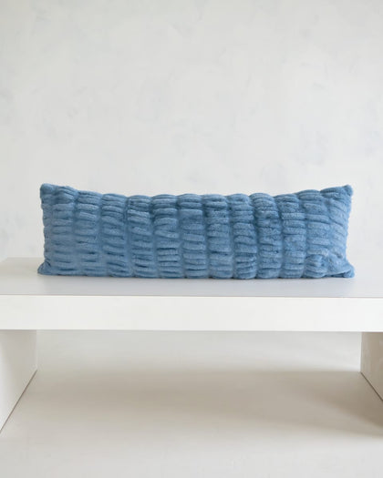 Hugs Denim Sham on a white table, showcasing its soft texture and denim blue color for stylish comfort.