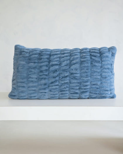 Hugs Denim Sham on a white shelf, featuring a soft, cozy, textured design in timeless denim blue.