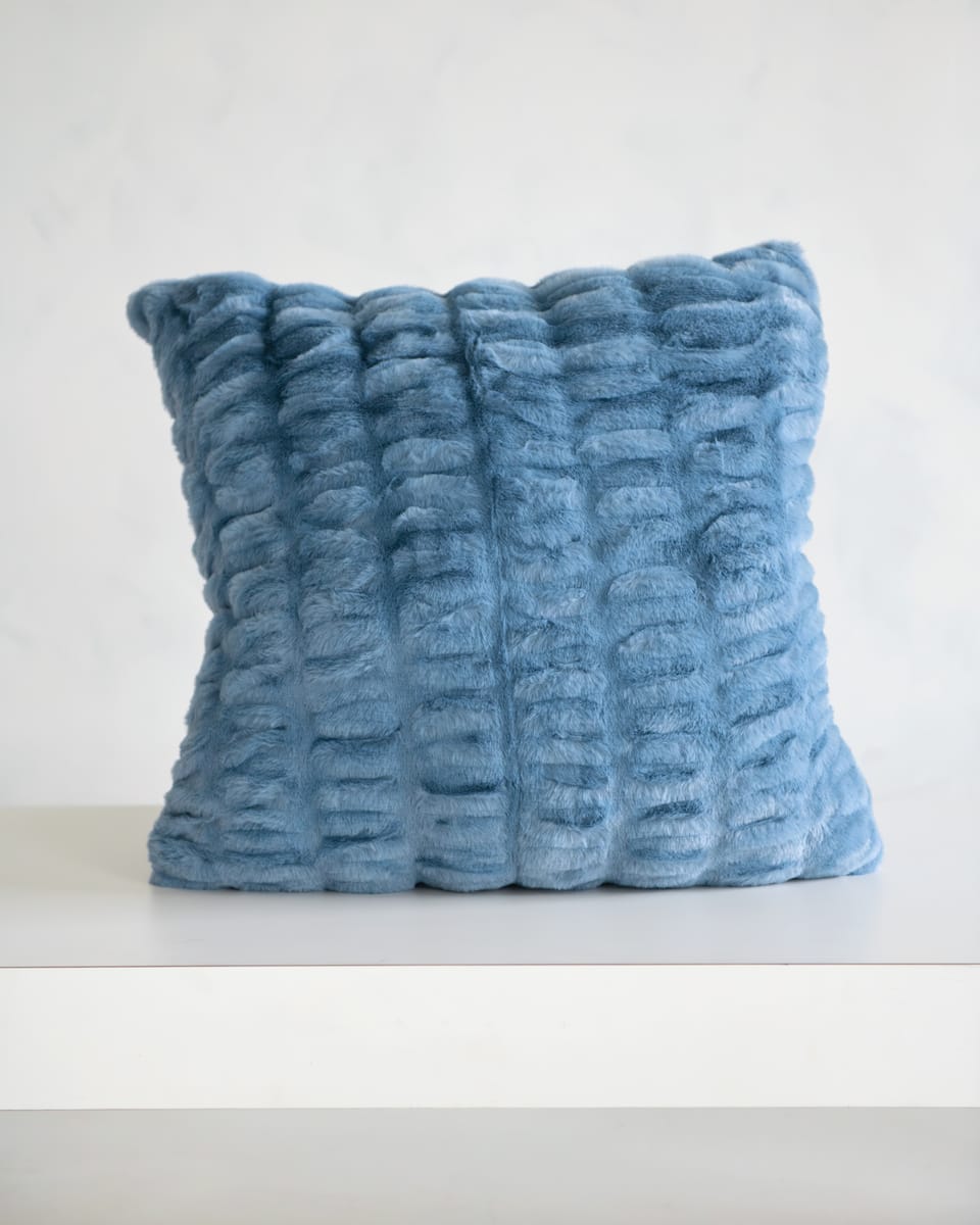 Hugs Denim Sham in soft blue plush fabric on a white surface, perfect for cozying up any space.