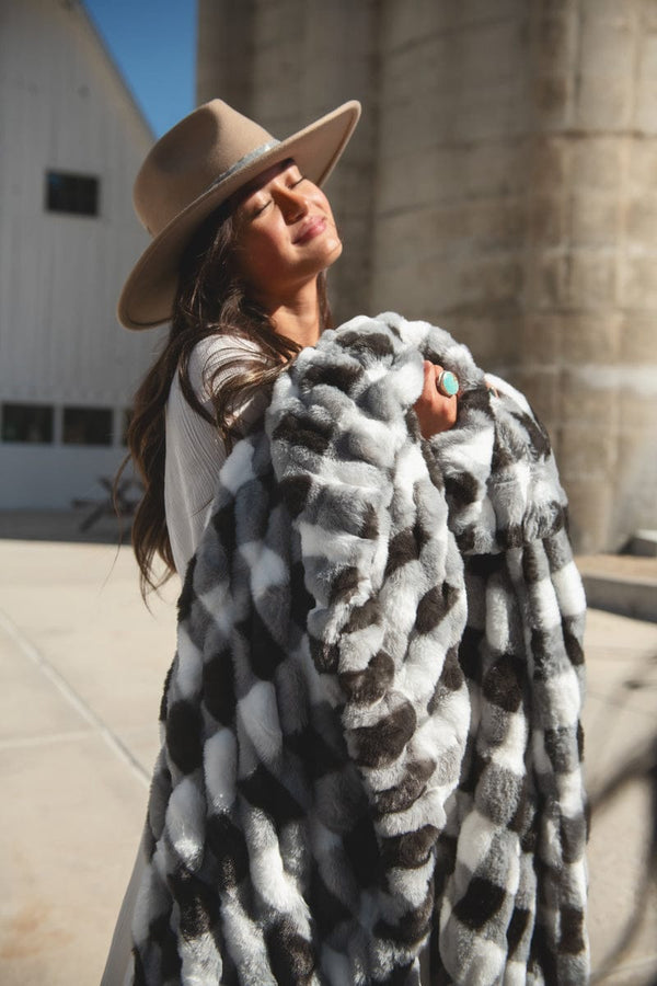 Young woman basking in the sunlight with a charcoal gingham check blanket.