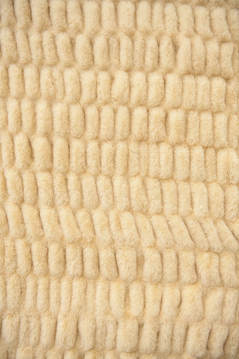 Close-up of textured beige fabric with a wavy pattern.