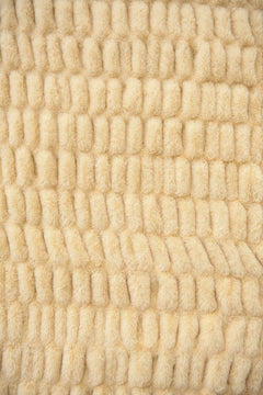 Close-up of textured beige fabric with a wavy pattern.