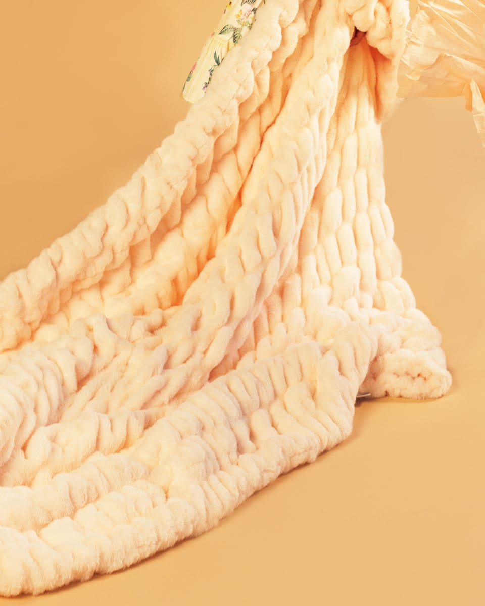 Pastel orange blanket being dragged across a matching colored background.