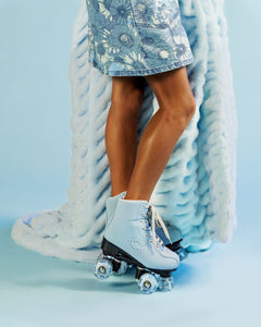 Person wearing light blue roller skates while holding a light blue blanket.