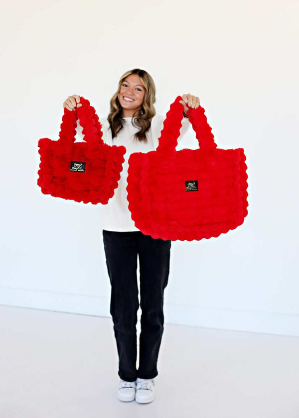 A model showcasing the Annie Bag Ripple Red in small and large sizes, highlighting its luxurious style and texture.
