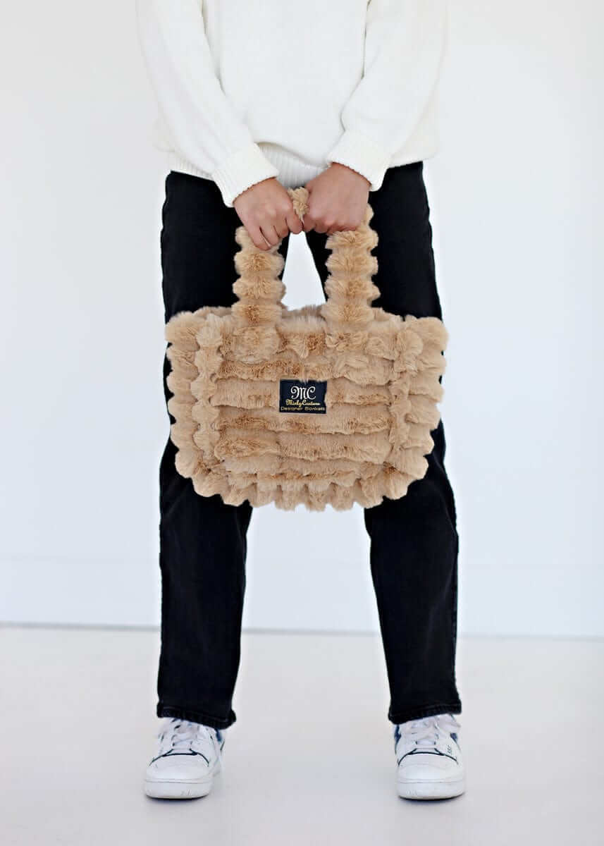 Ripple Ecru Annie Bag held by a model, showcasing luxurious texture and stylish design.