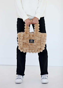 Ripple Ecru Annie Bag held by a model, showcasing luxurious texture and stylish design.