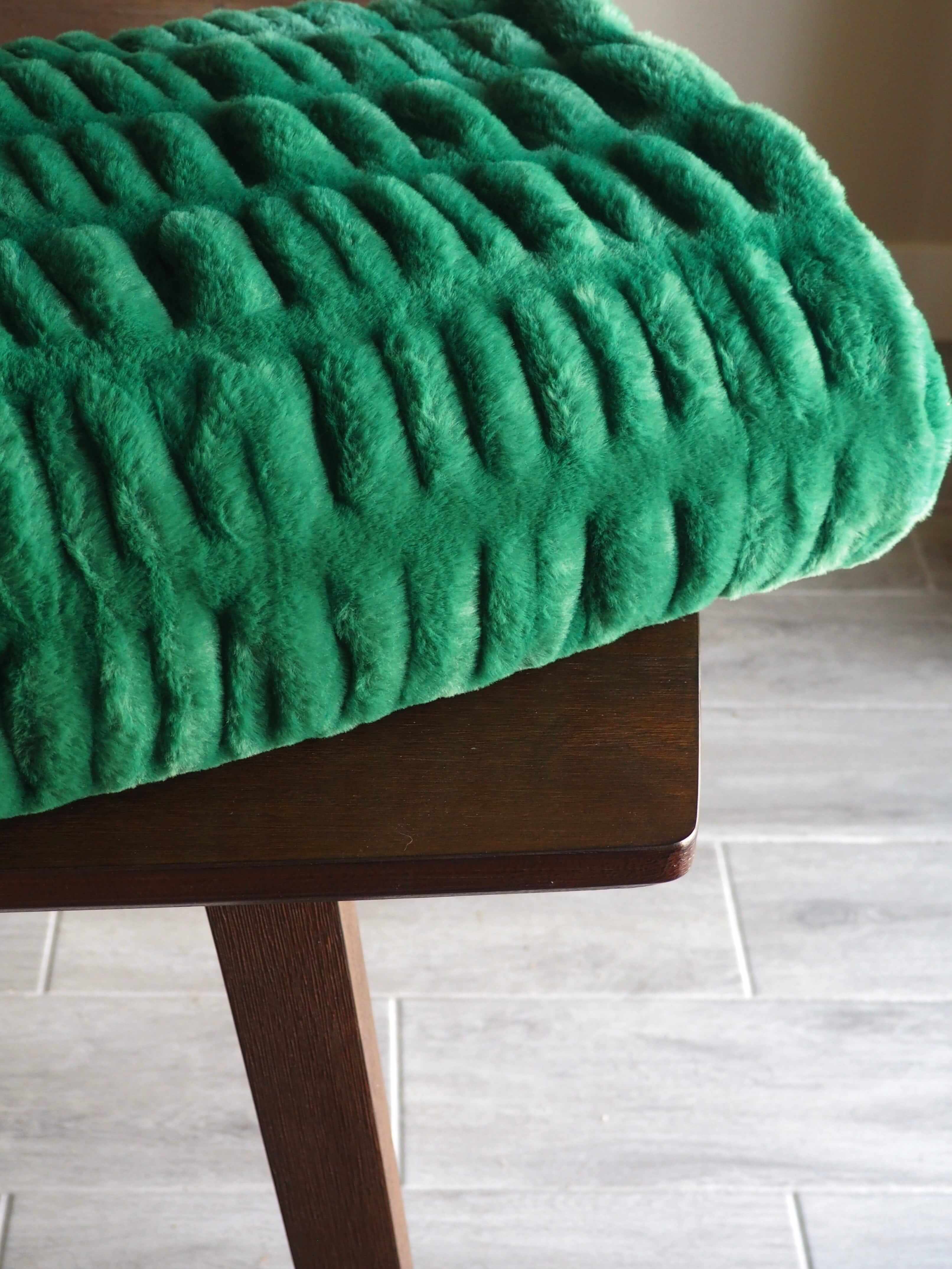 Hugs Green Blanket displayed on a wooden table, showcasing its plush texture and vibrant green color.