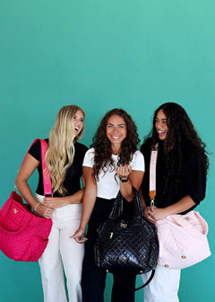 Three friends showcasing their stylish Everything Bag Patent Leather alongside colorful options on a vibrant backdrop.
