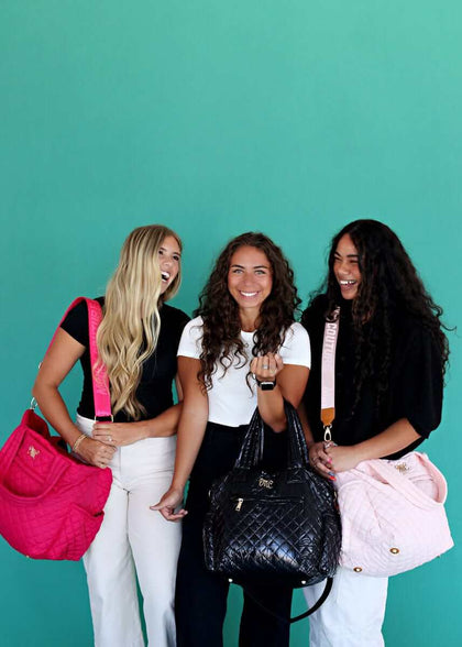 Three friends showcasing their stylish Everything Bag Patent Leather alongside colorful options on a vibrant backdrop.