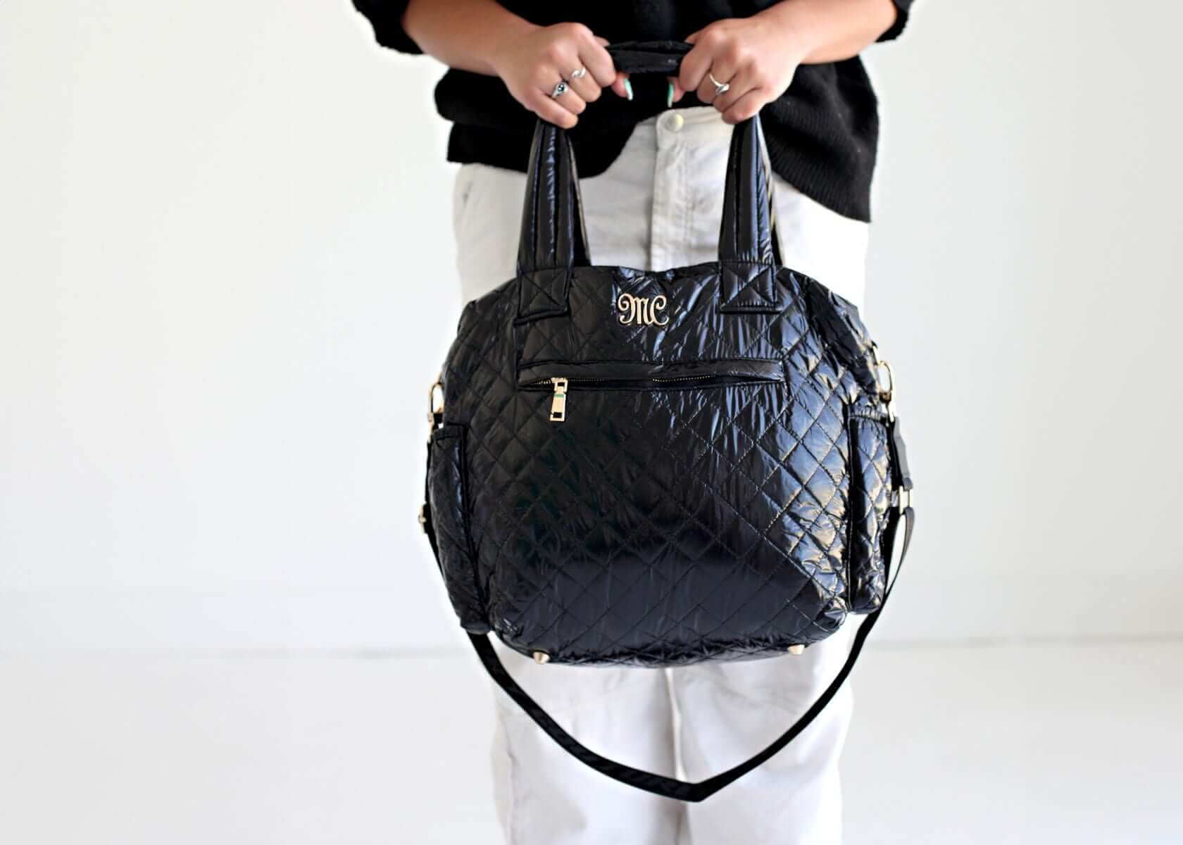Stylish Patent Leather Black Everything Bag being held, showcasing quilted patent leather and versatile design.