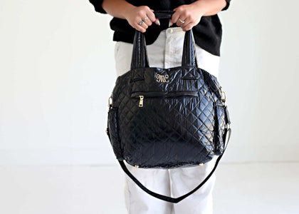 Stylish Patent Leather Black Everything Bag being held, showcasing quilted patent leather and versatile design.