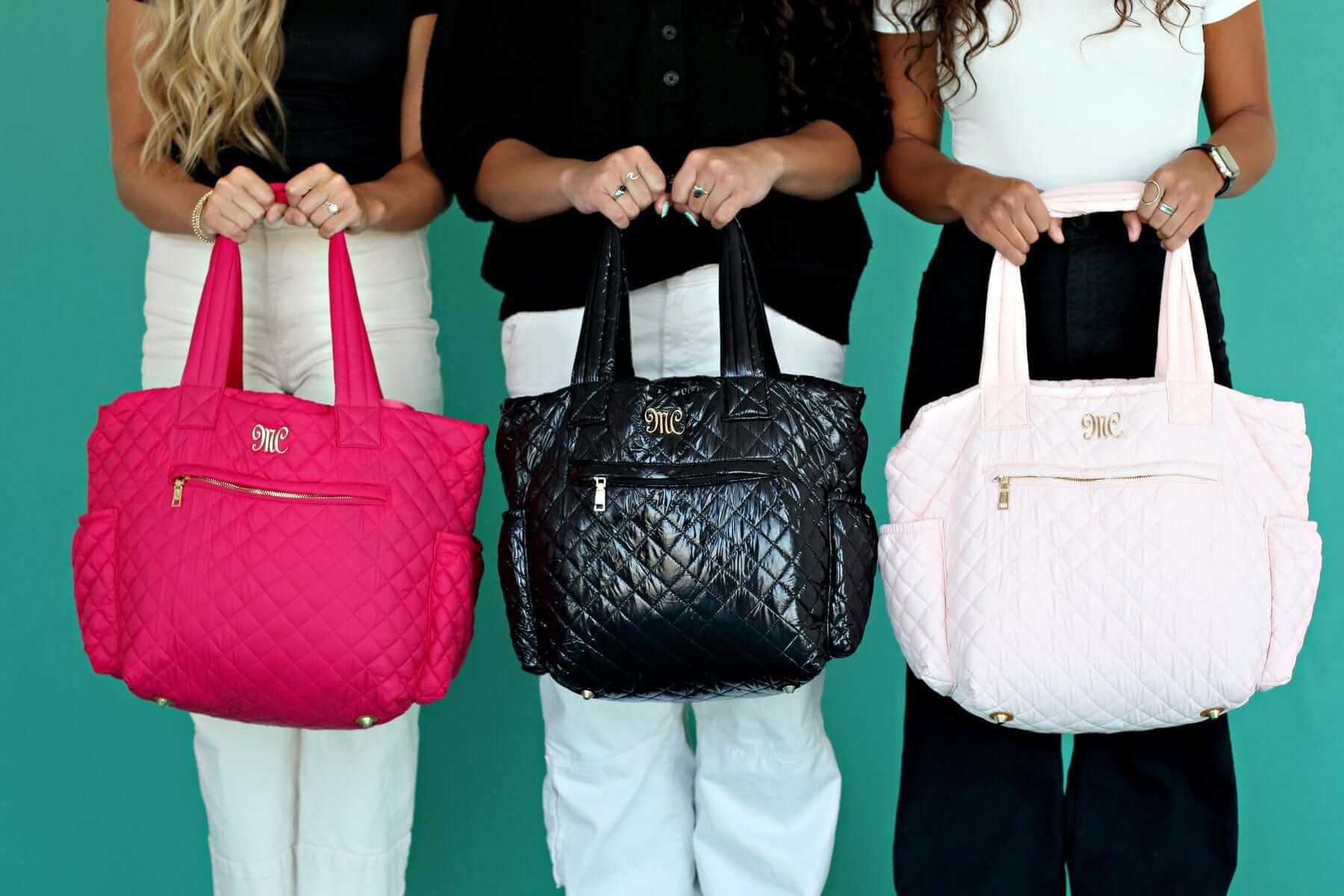 Three women holding stylish Everything Bag Patent Leather in black, pink and white variants.