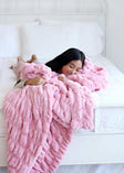 Hugs Cookie Pink Blanket on a bed, showcasing its cozy and soft texture for ultimate comfort.