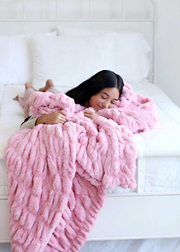 Hugs Cookie Pink Blanket on a bed, showcasing its cozy and soft texture for ultimate comfort.