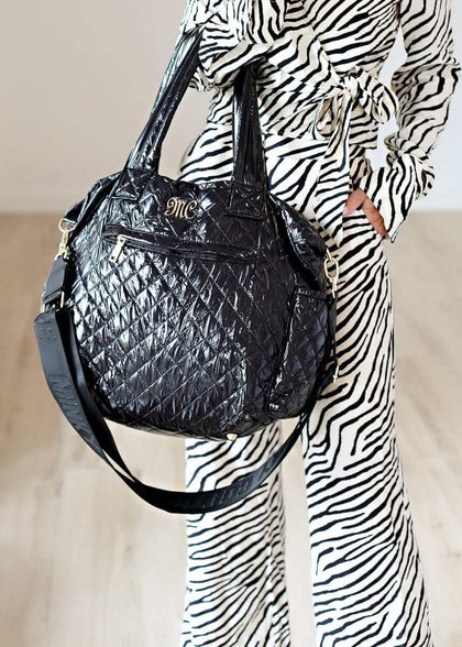 Everything Bag Patent Leather Black displayed with a stylish outfit, showcasing its versatile and chic design.
